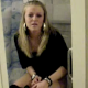 A pretty, blonde, Scandinavian girl is video-recorded by her friends as she tries pooping while sitting on a toilet. No audible pooping sounds.